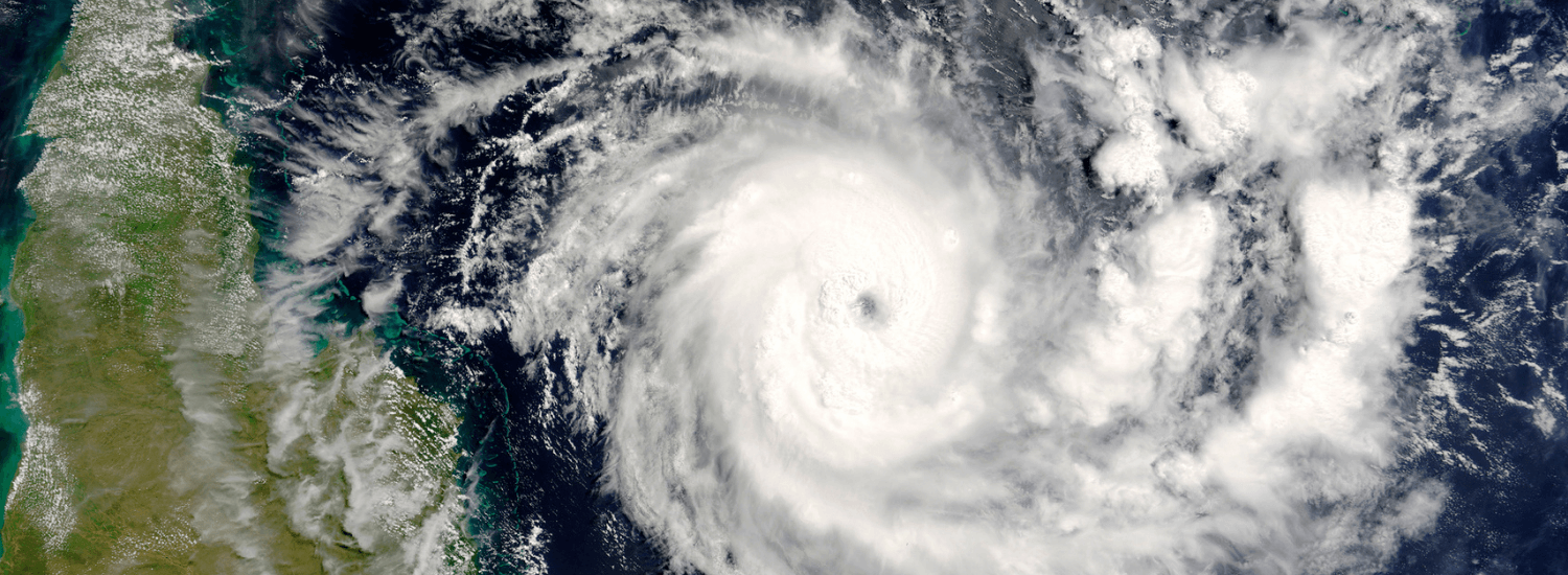 Top view of a cyclone travelling over water about to hit land